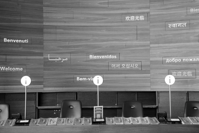 Welcome signs in multiple languages on wooden wall